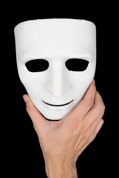 Hand hält weiße Maske auf schwarzem Hintergrund. — Stockfoto