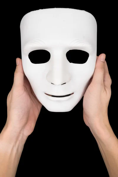 Hands holding white mask on black background. — Stock Photo, Image