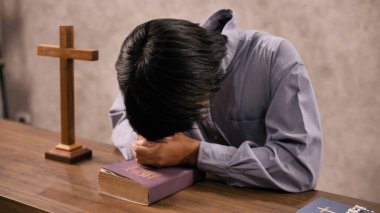 Genç bir Asyalı Hristiyan kilisede İsa 'ya dua ediyor..