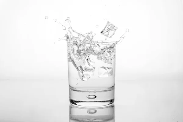 Salpicadura de agua con hielo en vidrio — Foto de Stock
