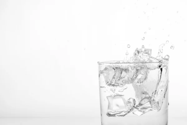 Wasserspritzer mit Eis im Glas — Stockfoto