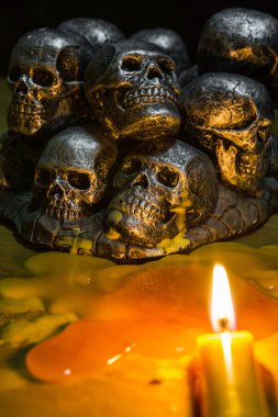 skulls with candle burning on wooden background in the darkness  clipart