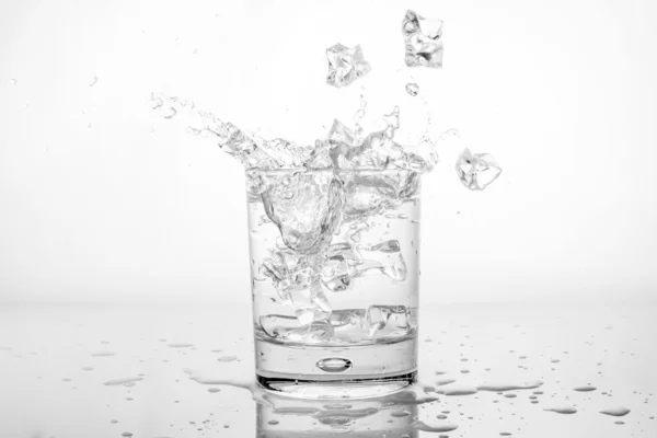 Wasserspritzer mit Eis im Glas — Stockfoto