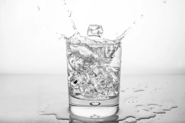 Salpicadura de agua con hielo en vidrio — Foto de Stock
