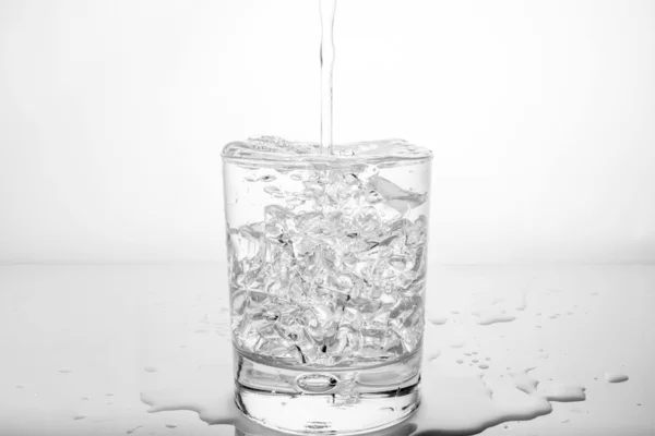 Glass with ice and splashing water — Stock Photo, Image