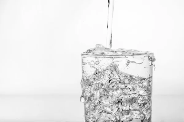 Glass with ice and splashing water — Stock Photo, Image