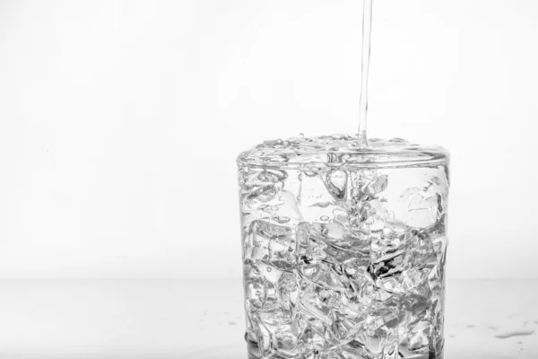 Vaso con hielo y agua salpicada —  Fotos de Stock