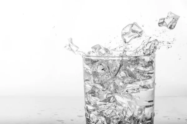 Wasserspritzer mit Eis im Glas — Stockfoto
