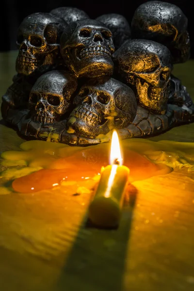 Skulls with candle burning on wooden background in the darkness — Stock Photo, Image