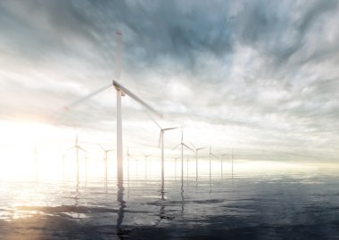 Günbatımı fırtınalı gökyüzü arka planda offshore rüzgar türbinleri