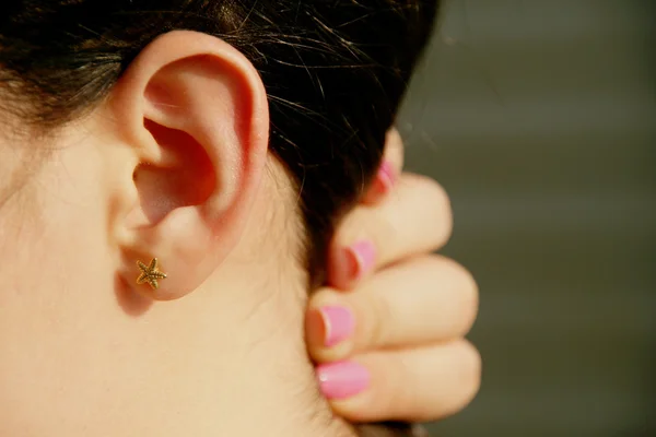 Female holding hair to side close up of ear — Stock Photo, Image