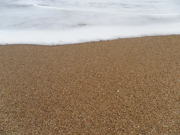 Песчаный пляж с приближающейся волной — стоковое фото