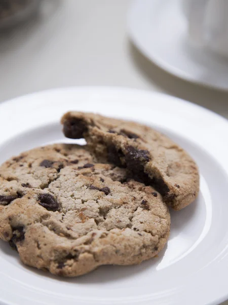 Čokoláda čip cookies na bílém štítku s šálek kávy — Stock fotografie