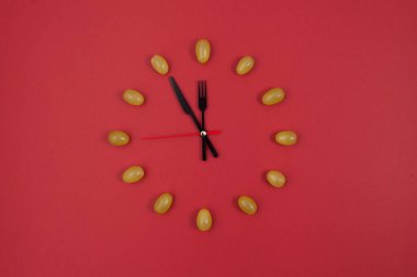 Kırmızı arka planda 12 parça üzümlü saat. Kopya alanı olan yeni yıl kompozisyonu.