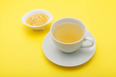 Yujacha (yuja çayı veya yuzu çayı) - Popüler Kore çayı. Bal limonlu içecek. Sarı arkaplan, seçici odak.