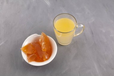 Pıhtılaşmış jöle gibi ev yapımı et kemiği çorbası, doğal kolajen, gri arka planda şeffaf bardakta sıvı bulyon. Üst görünüm, alanı kopyala.