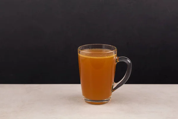 Doğal kolajenle ev yapımı et kemiği çorbası. Şeffaf bardakta Bouillon. Seçici odak, boşluğu kopyala.