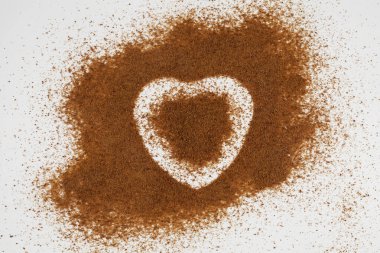 Hindistan cevizi palmiye şekeri kaotik bir şekilde kalp şeklinde bir hale ile bir yüzeye saçılmıştır..