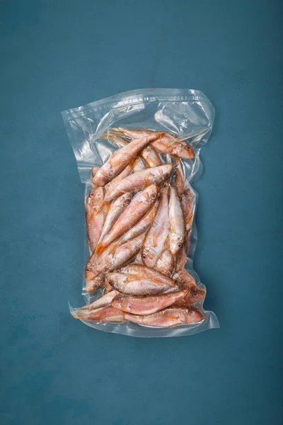 Frozen fish Mullus barbatus (red mullet) in pack. Goatfish found in Mediterranean Sea, Black Sea and eastern North Atlantic Ocean. Top view, copy space.