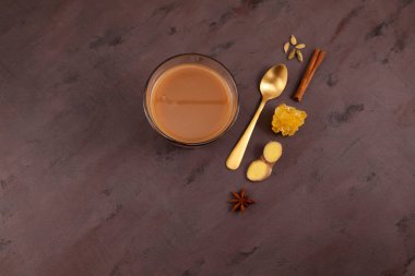 Popüler Hintli Karak çayı ya da Masala çayı içer. Süt, baharat ve çeşitli baharatlar eklenerek hazırlandı. Üst görünüm, kahverengi arkaplan, seçici odak, kopyalama alanı.