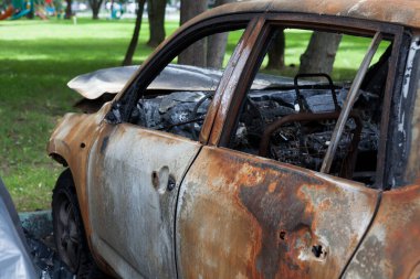 Yanmış araba. Paslanmış vücut parçaları, arabanın içi tamamen yanmış..