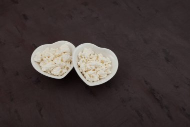 Kupa şeklinde beyaz kaselerde süzme peynir. Organik ekolojik sağlıklı yiyecekler. Doğal süt ürünü. Seçici odak, boşluğu kopyala.