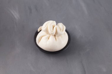 Yumuşak bir kese İtalyan peyniri. Burrata veya mozzarella ve krem dolgu malzemesinden yapılmış burratina peyniri. Seçici odak, gri arkaplan, boşluğu kopyala.