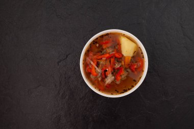 Karanlık taş zemin üzerinde Shurpa ya da shorpa çorbası. Geleneksel Özbek yemeği kuzu, sebze ve baharatlı. Üst görünüm, alanı kopyala.