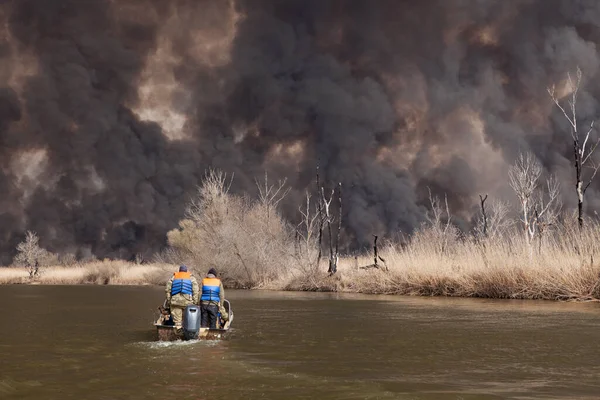 아스트라한 지역의 강기슭에서 화재가 했습니다 러시아 갈대를 때생기는 연기와 솟아올라 — 스톡 사진