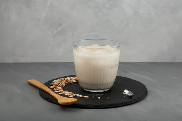 Misugaru Latte or Misutgaru. Healthy Korean multigrain shake on grey background. Popular homemade breakfast drink. Protein smoothie with roasted multi grain powder.