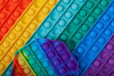 POP IT oyuncakları, komik eğitici çocuk oyuncakları ve el simülatörleri, yakın çekim. Seçici odak, boşluğu kopyala.