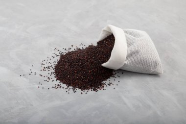 Gri arka planda kese içinde Ragi veya siyah kinoa, seçici odak, kopyalama alanı. Organik tahıllar büyük miktarda protein, antioksidan, diyet lifleri, vitaminler ve mineraller içerir..