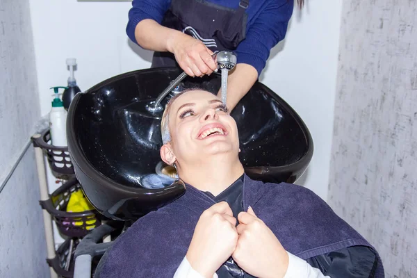 Młoda Kobieta Myje Głowę Salonie Fryzjerskim — Zdjęcie stockowe