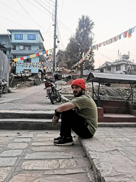 person on the street, man is sitting on the street