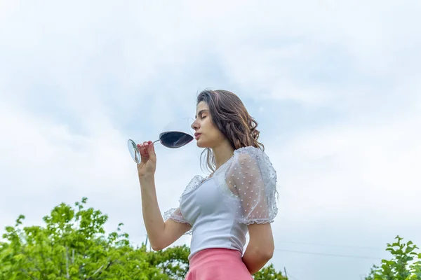 woman with wine, woman with glass of wine, woman drinking red wine in the garden