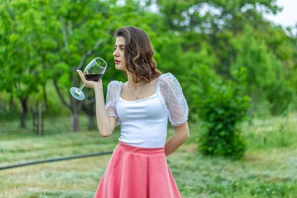 woman with wine, woman with glass of wine, woman drinking red wine in the garden