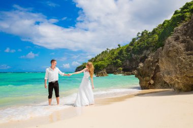 Happy Bride and Groom having fun on the tropical beach. Wedding 