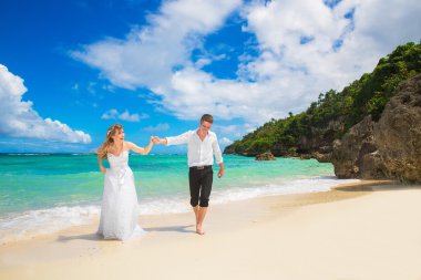 Happy Bride and Groom having fun on the tropical beach. Wedding 