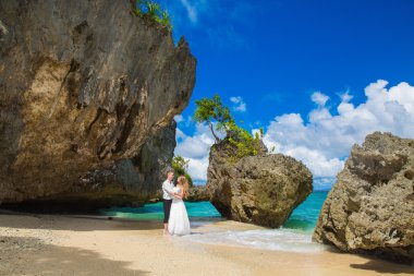 Happy Bride and Groom having fun on the tropical beach. Wedding 
