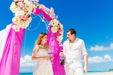 Mor bir tropik sahilde düğün töreni. Mutlu damat ve 