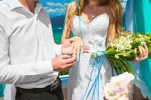 Brudgummen ger en förlovningsring till sin brud under hålfoten deco — Stockfoto