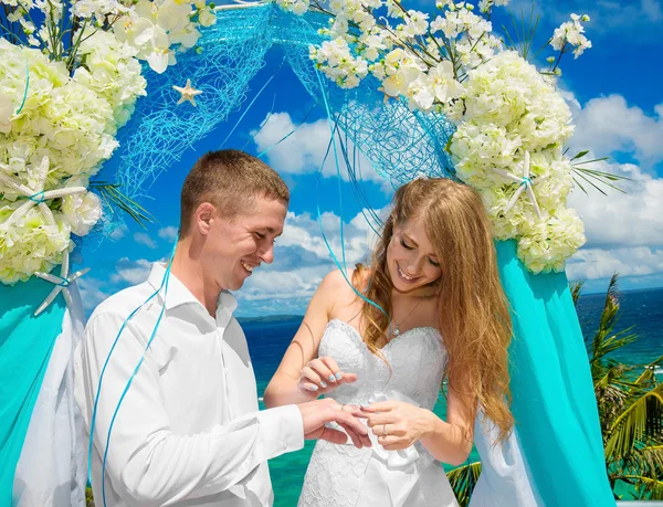 Bride giving an engagement ring to his groom under the arch deco — Stock Photo, Image