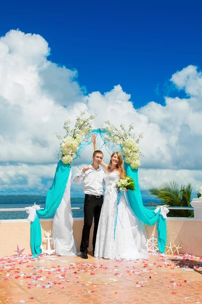 Trauung an einem tropischen Strand in Blau. glücklicher Bräutigam und br — Stockfoto