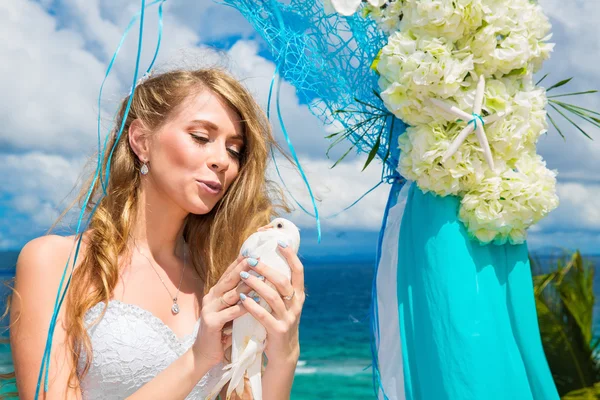 La sposa felice con colombe bianche su una spiaggia tropicale sotto palma — Foto Stock