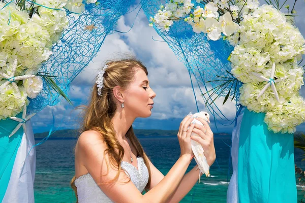 La sposa felice con colombe bianche su una spiaggia tropicale sotto palma — Foto Stock
