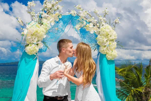 Lyckliga bruden och brudgummen med vita duvor på en tropisk strand u — Stockfoto