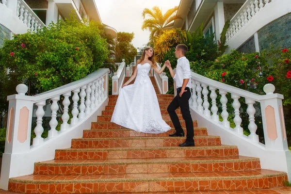Noiva e noivo em pé nas escadas do hotel em uma trópica — Fotografia de Stock
