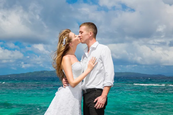 Happy bride and groom having fun on a tropical beach under the p — Stock Photo, Image