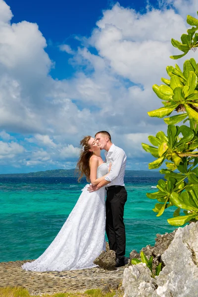 Novia feliz y novio divirtiéndose en una playa tropical bajo el p —  Fotos de Stock