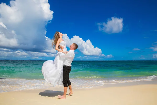 Glückliche Braut und Bräutigam haben Spaß an einem tropischen Strand. Hochzeit ein — Stockfoto